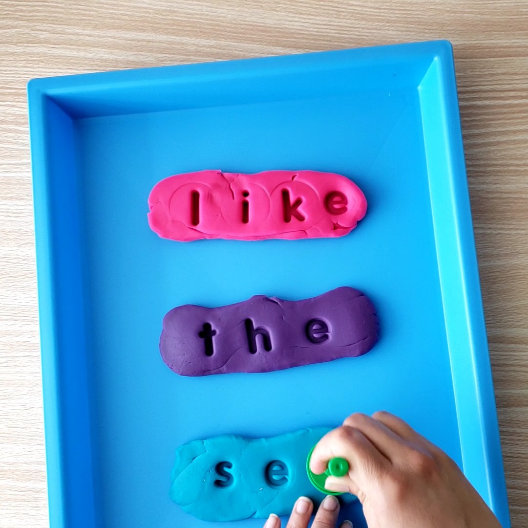 playdough being stamped with letters